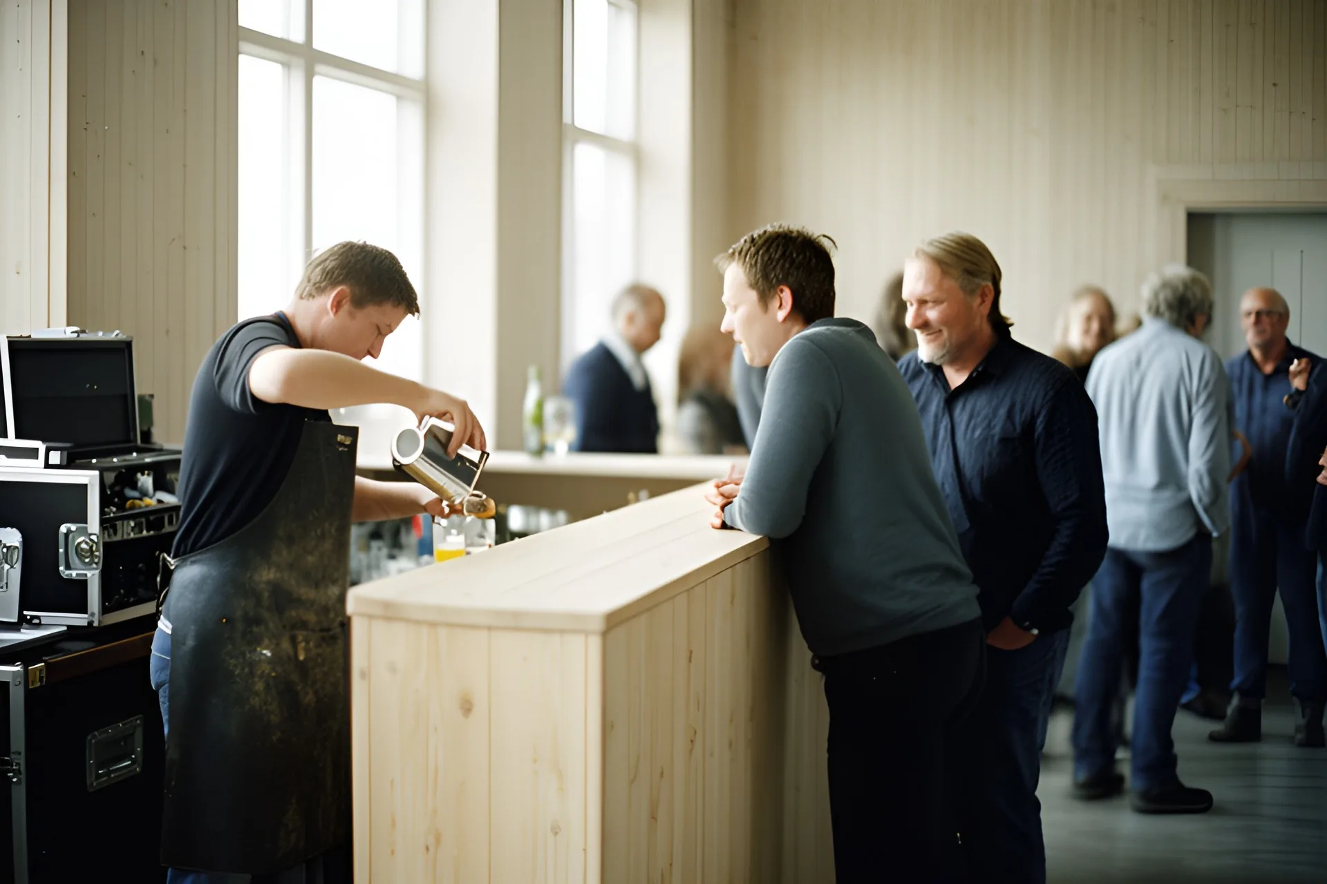 Bartender ved en bardisk med flasker og glas bag disken
