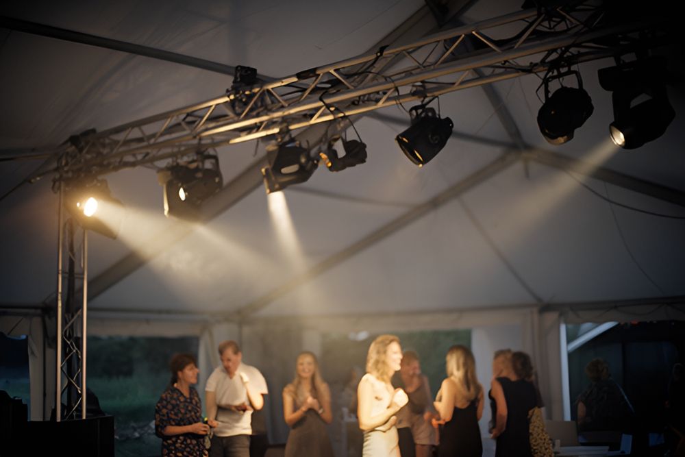 Lysrig med spots over et dansegulv i et festtelt om aftenen
